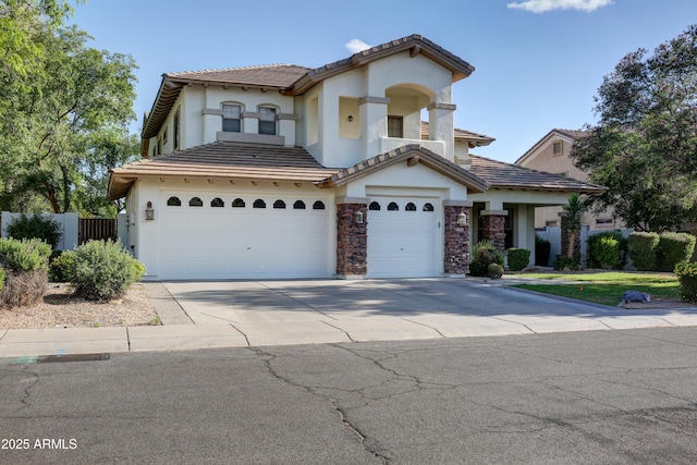 1707 E Carob Dr, Chandler, AZ 85286 - mediterranean / spanish house with stucco siding, concrete driveway, a garage, fence, and stone siding