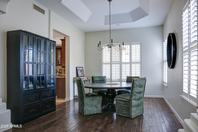 1707 E Carob Dr, Chandler, AZ 85286 - dining area with a chandelier, dark wood-type flooring, a raised ceiling, and baseboards