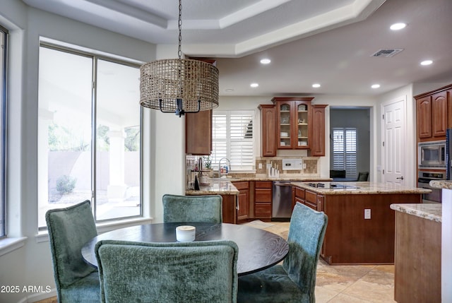 1707 E Carob Dr, Chandler, AZ 85286 - kitchen featuring stainless steel appliances, glass insert cabinets, recessed lighting, a center island, and light stone countertops