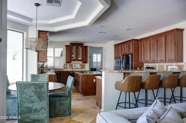 1707 E Carob Dr, Chandler, AZ 85286 - kitchen featuring a peninsula, smart refrigerator, a kitchen bar, light stone counters, and glass insert cabinets
