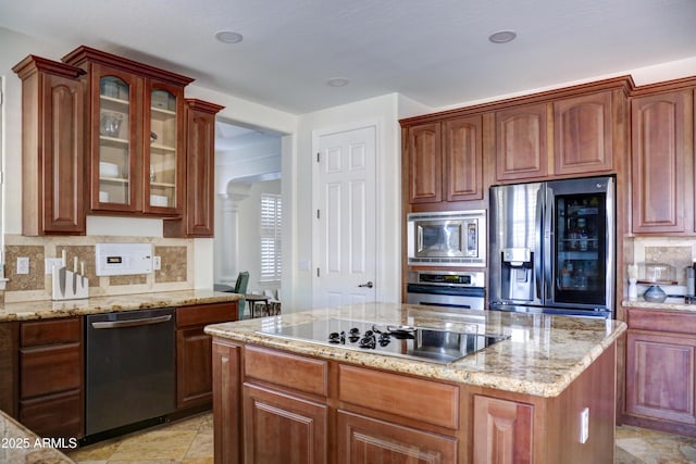 1707 E Carob Dr, Chandler, AZ 85286 - kitchen featuring stainless steel appliances, a kitchen island, backsplash, glass insert cabinets, and light stone countertops