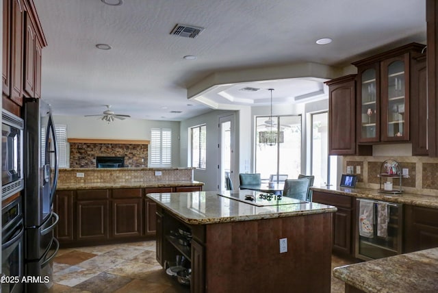 1707 E Carob Dr, Chandler, AZ 85286 - kitchen with beverage cooler, stainless steel fridge with ice dispenser, electric stovetop, tasteful backsplash, and a ceiling fan
