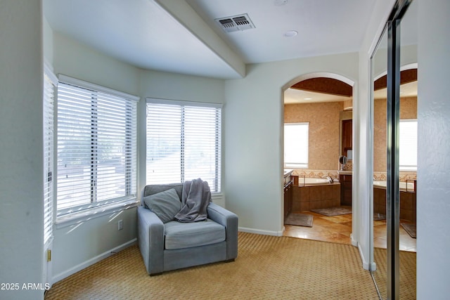 1707 E Carob Dr, Chandler, AZ 85286 - living area with arched walkways, baseboards, and light colored carpet