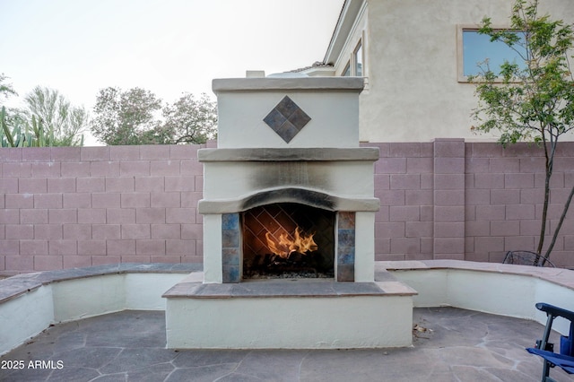 1707 E Carob Dr, Chandler, AZ 85286 - view of patio with a lit fireplace and fence