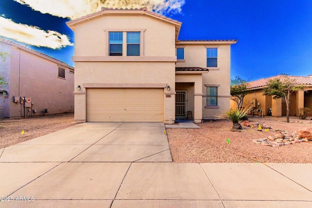 view of front of home with a tile roof, driveway, an attached garage, and stucco siding