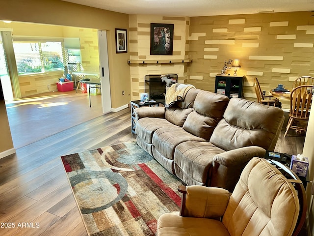 living room featuring light wood-type flooring and a large fireplace