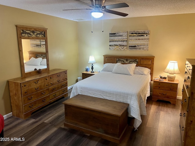 bedroom featuring dark wood-type flooring, a textured ceiling, and ceiling fan