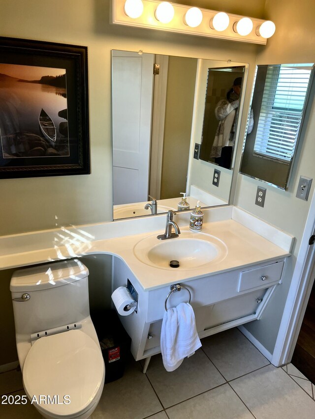 bathroom with toilet, vanity, and tile patterned floors