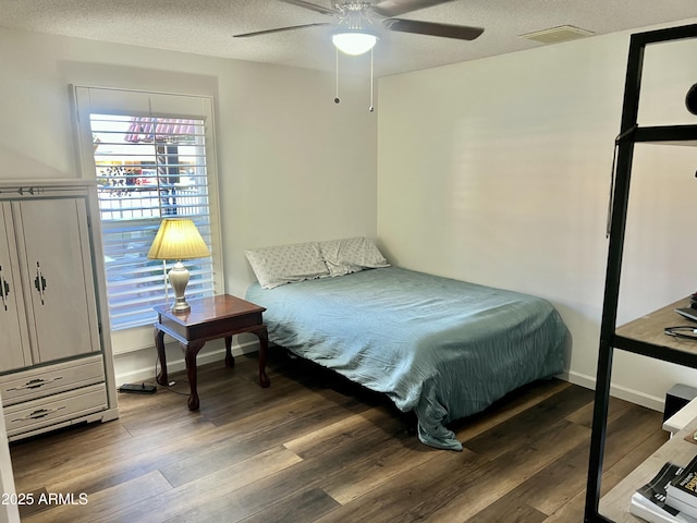 bedroom with ceiling fan, a textured ceiling, and hardwood / wood-style flooring