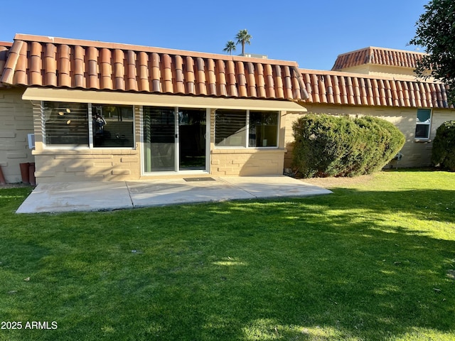 rear view of house with a patio and a lawn