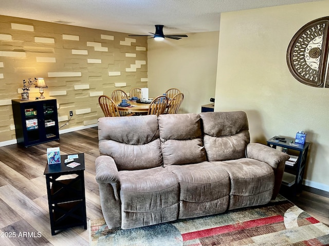 living room featuring a textured ceiling, ceiling fan, and dark hardwood / wood-style floors