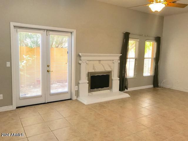 unfurnished living room with plenty of natural light, ceiling fan, and light tile patterned floors