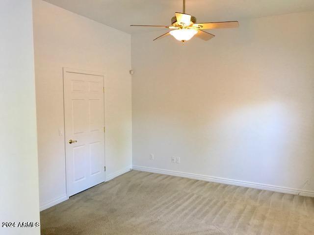 carpeted empty room featuring ceiling fan