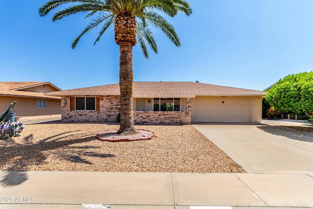 9603 W Calico Dr, Sun City, AZ 85373 - single story home featuring brick siding, a garage, driveway, and roof with shingles