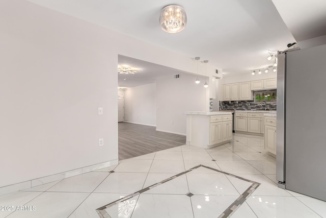 9603 W Calico Dr, Sun City, AZ 85373 - kitchen with freestanding refrigerator, light countertops, decorative backsplash, and light tile patterned floors