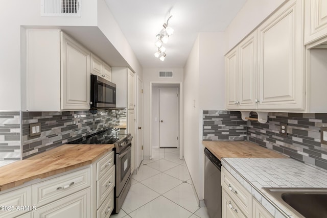 9603 W Calico Dr, Sun City, AZ 85373 - kitchen with butcher block countertops, stainless steel appliances, tasteful backsplash, and light tile patterned flooring