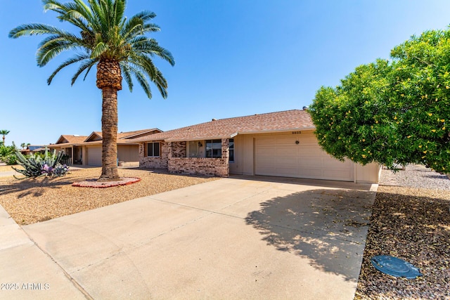9603 W Calico Dr, Sun City, AZ 85373 - single story home with an attached garage, driveway, and brick siding