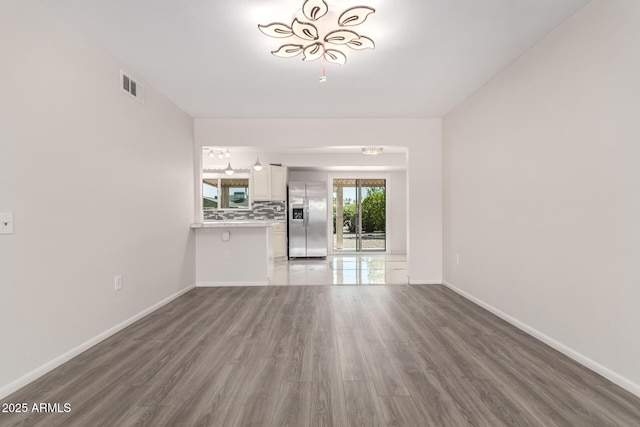 9603 W Calico Dr, Sun City, AZ 85373 - unfurnished living room with wood finished floors and baseboards