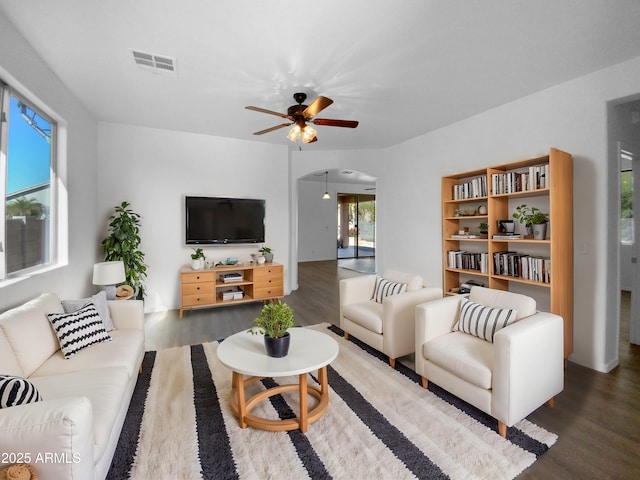 living room featuring dark wood-type flooring and ceiling fan