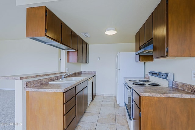 kitchen featuring light tile patterned floors, under cabinet range hood, white appliances, a sink, and visible vents