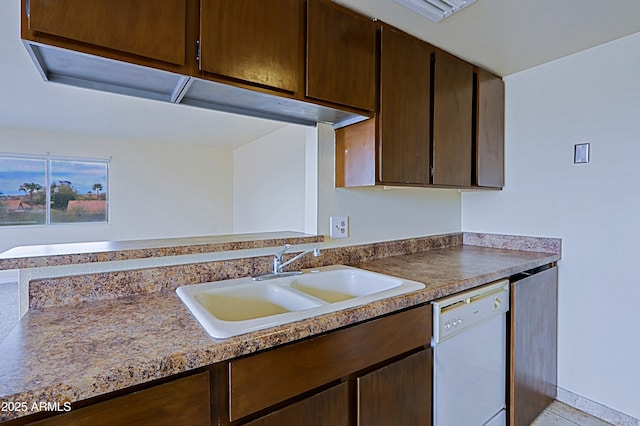 kitchen featuring dark brown cabinets, white dishwasher, and a sink