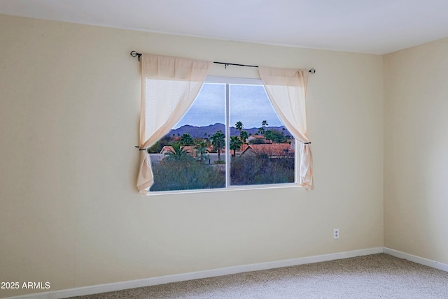 empty room featuring carpet floors and baseboards