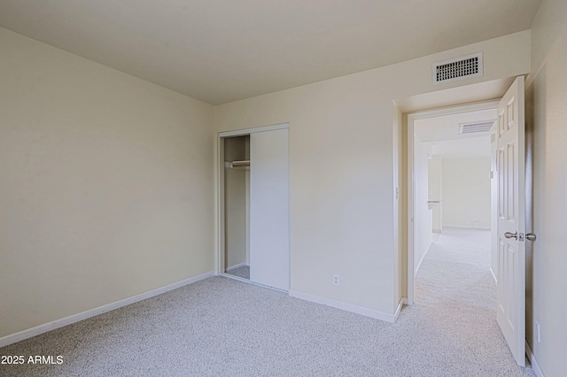 unfurnished bedroom with light colored carpet, a closet, visible vents, and baseboards