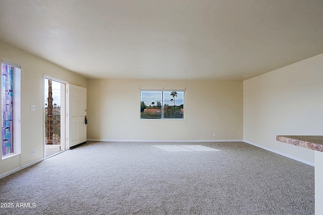 spare room with light carpet and baseboards