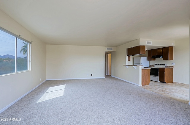 unfurnished living room with light colored carpet, visible vents, and baseboards