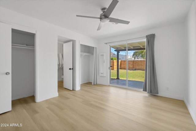 unfurnished bedroom featuring multiple closets, access to exterior, light hardwood / wood-style floors, and ceiling fan