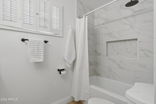 bathroom featuring shower / bath combination with curtain and toilet