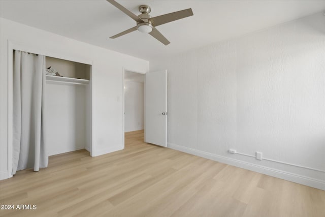 unfurnished bedroom with light hardwood / wood-style flooring, a closet, and ceiling fan