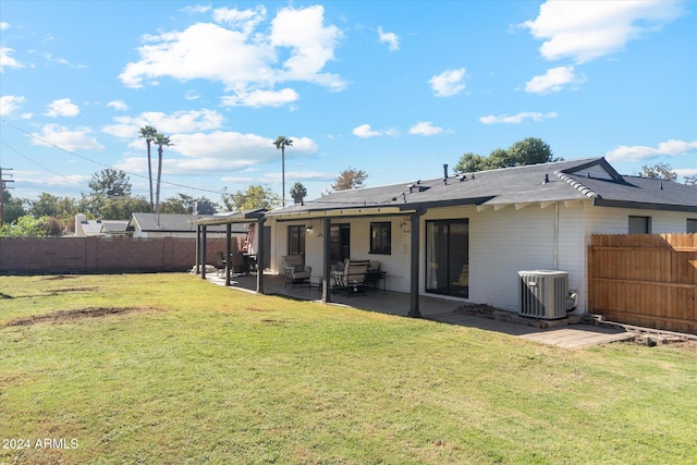 back of property with a yard, a patio area, and central AC