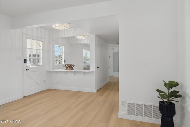 interior space featuring an inviting chandelier and light wood-type flooring