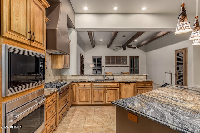 kitchen featuring wall chimney range hood, ceiling fan, stainless steel appliances, beamed ceiling, and dark stone counters