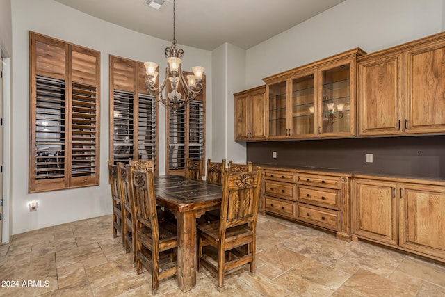 dining space featuring a chandelier, visible vents, and stone tile flooring