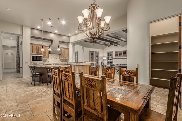 dining room featuring beamed ceiling, sink, and ceiling fan with notable chandelier