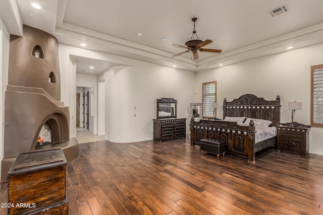 bedroom featuring wood-type flooring, recessed lighting, a tray ceiling, and visible vents