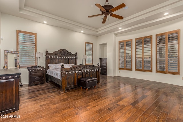 bedroom featuring recessed lighting, wood finished floors, and a tray ceiling