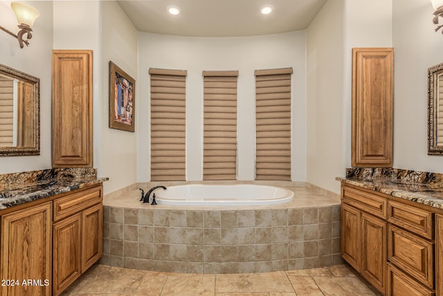 full bath with recessed lighting, a bath, and two vanities