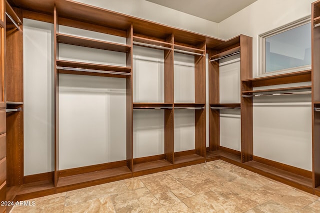 spacious closet with stone finish flooring
