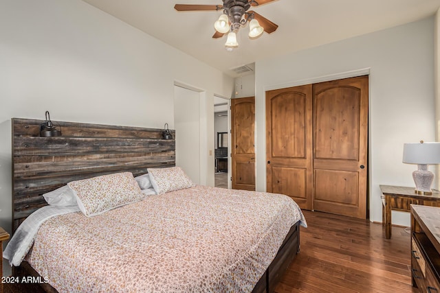 bedroom with a closet, a ceiling fan, visible vents, and dark wood-type flooring