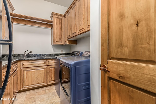 laundry room with a sink, stone finish flooring, cabinet space, and washer and dryer