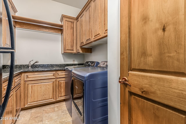 laundry room featuring sink, washer and dryer, and cabinets