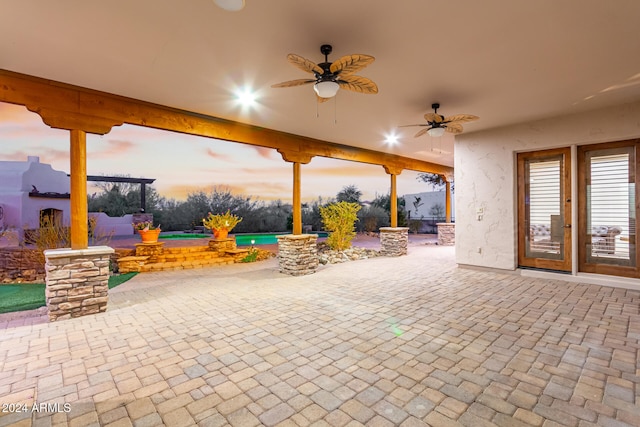 patio terrace at dusk with ceiling fan and a pool