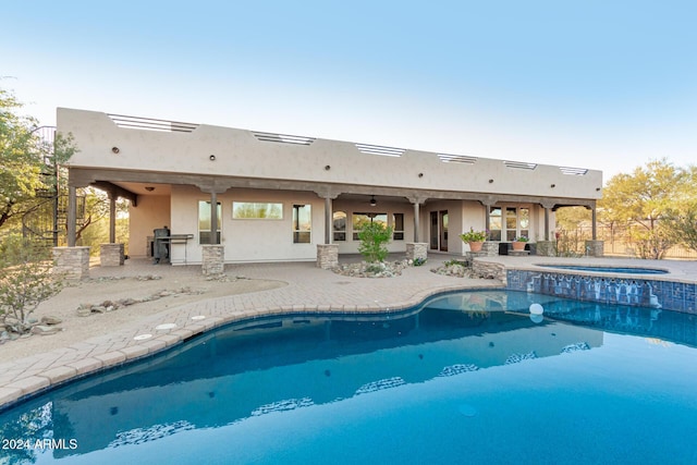 view of swimming pool with ceiling fan, a patio area, a pool with connected hot tub, and a grill
