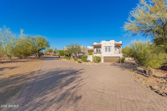 view of front facade with an attached garage, decorative driveway, and stucco siding
