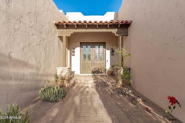 entrance to property with stucco siding and a tiled roof