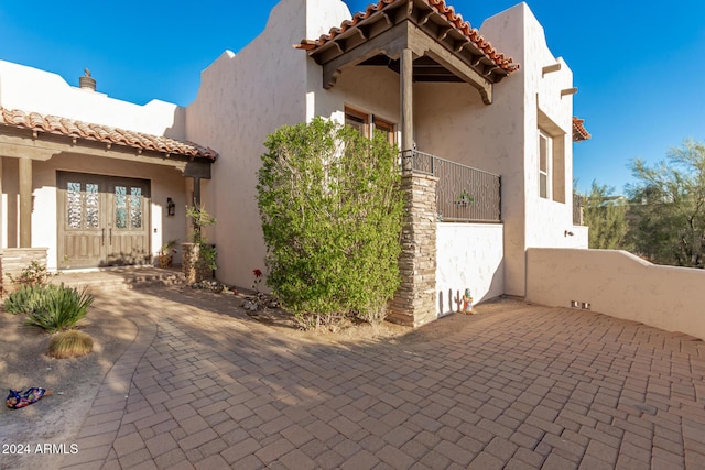 exterior space with stucco siding and a tiled roof