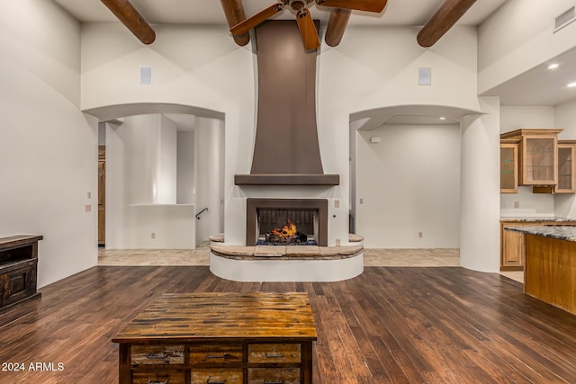 living room with a ceiling fan, high vaulted ceiling, beam ceiling, and arched walkways